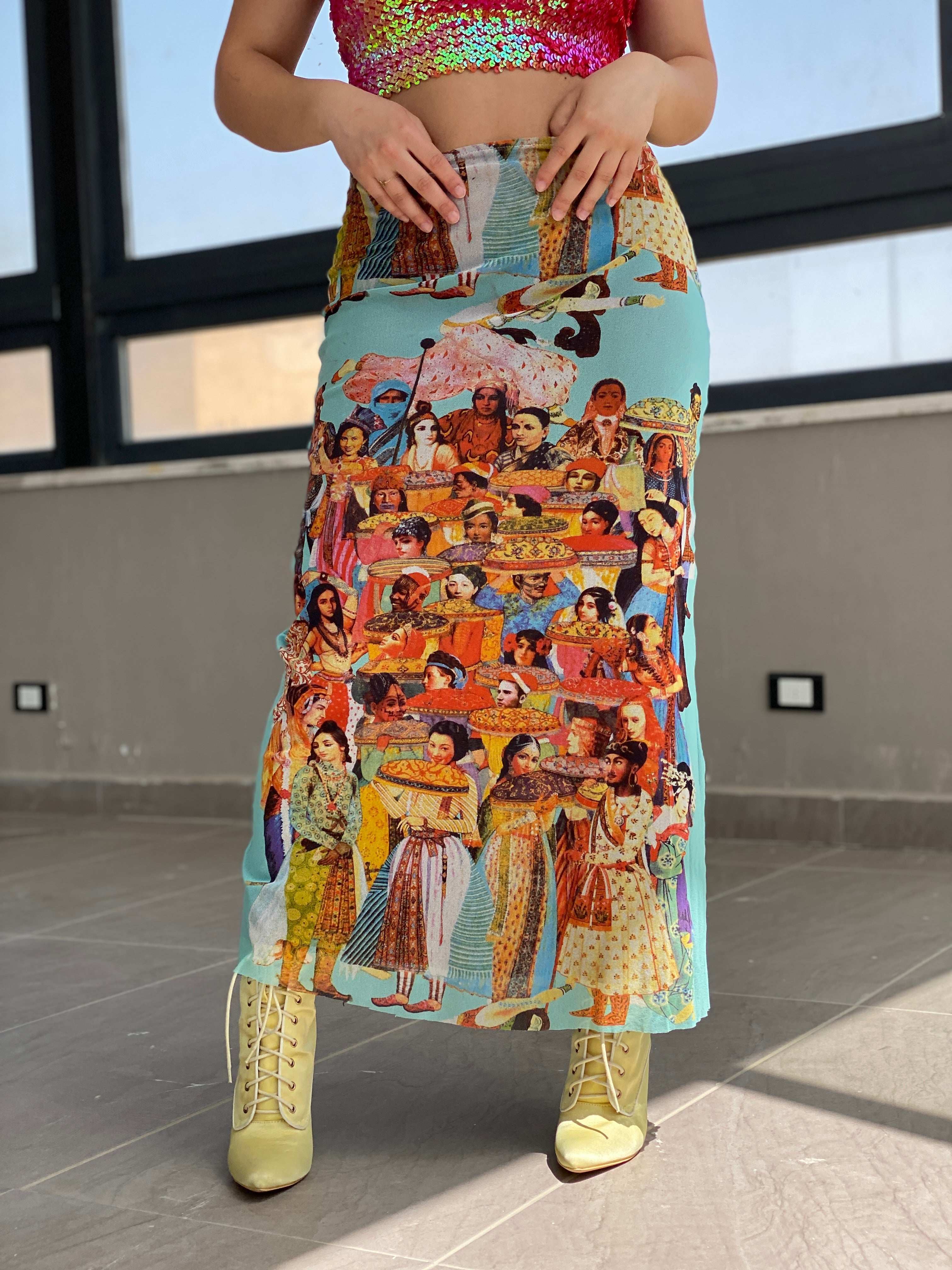 Vintage-inspired midi skirt with colorful global cultural print, paired with sequin crop top and yellow boots