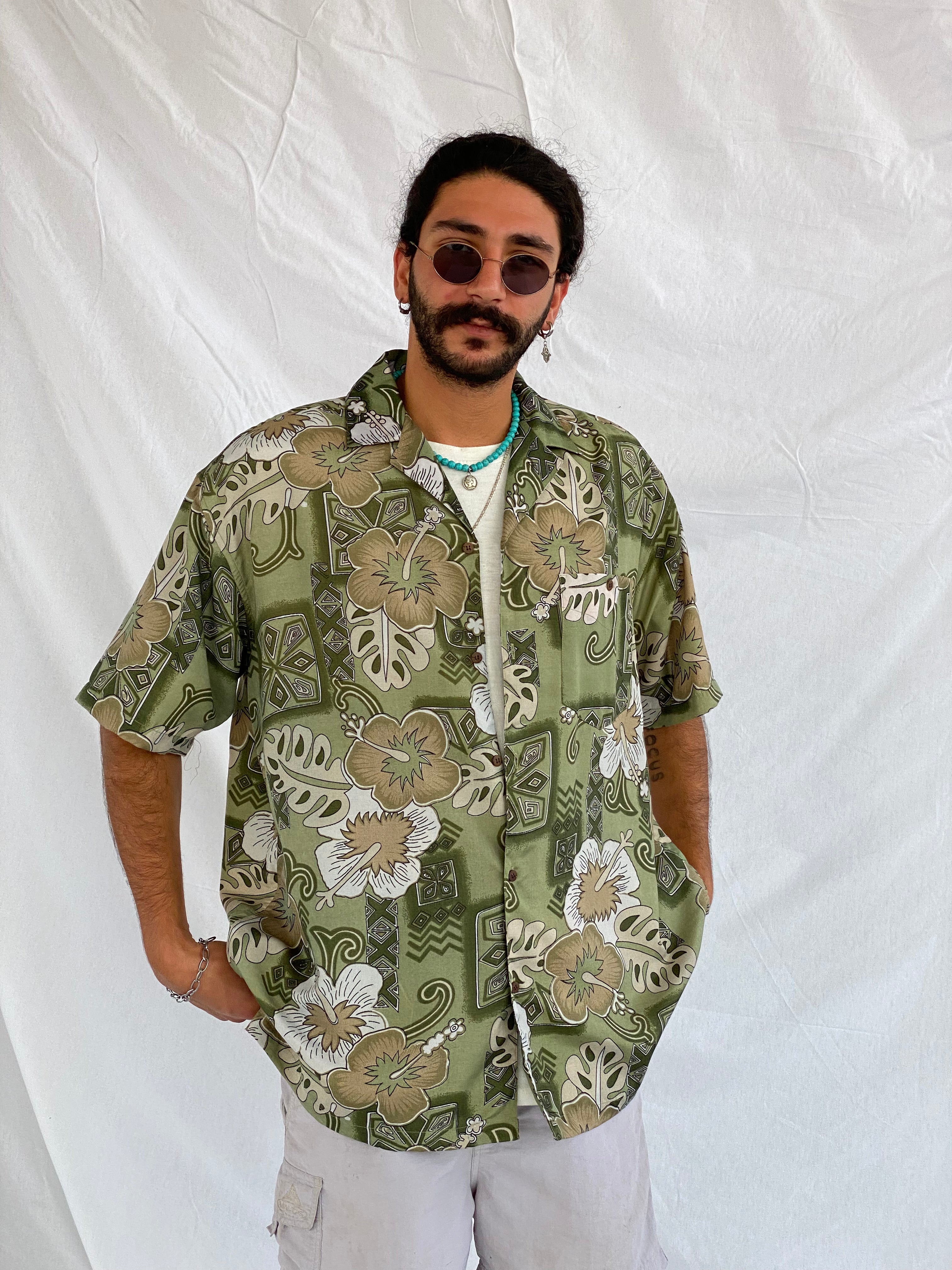 Man wearing olive green vintage floral print shirt from Balagan Vintage, standing against white backdrop.